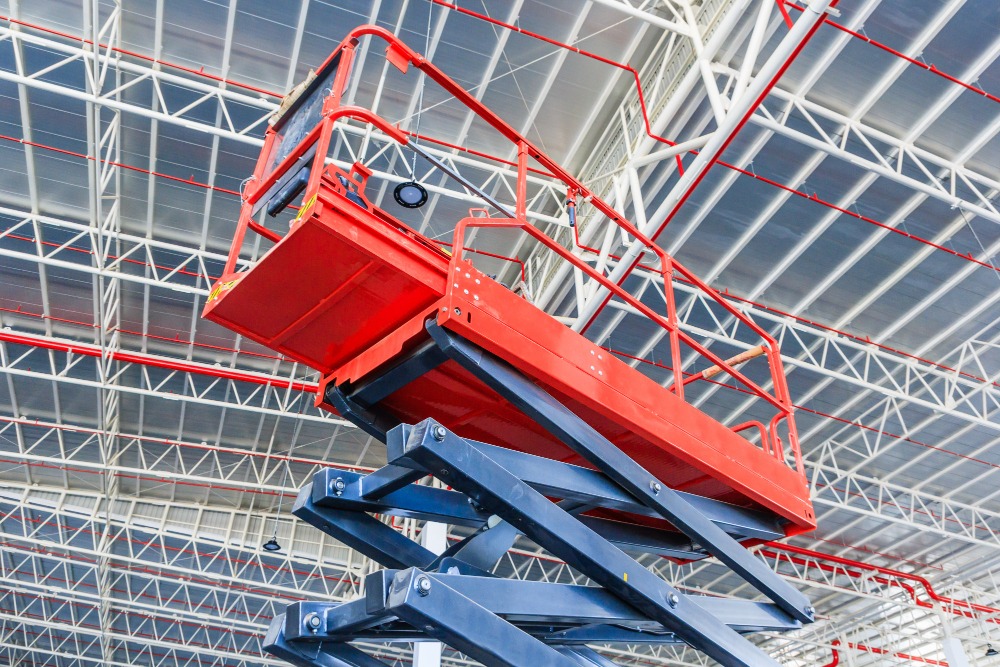 Scissor lift platform with hydraulic system elevated towards a factory roof