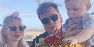 Elon Musk, Grimes, and their baby are seen enjoying flowers together.