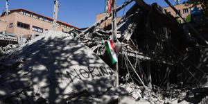 Bandeiras iranianas são vistas sobre os escombros de prédio da Universidade de T