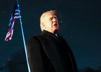 EPA US President Donald Trump responds to a question from the news media as he walks to board Marine One on the South Lawn of the White House. An American flag