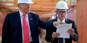 s US President Donald Trump directs the attention of Federal Reserve Chair Jerome Powell to documents, during a July 2025 tour of the Federal Reserve's $2.5bn h
