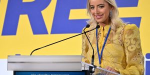 Ashley St Clair in front of a yellow sign