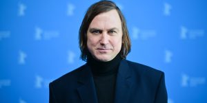 m colorida do ator Lars Eidinger posando para fotos em tapete vermelho