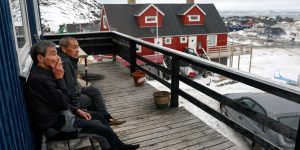 Men relax outside their home on March 10, 2025 in Ilulissat, Greenland. US President Donald Trump has pledged to acquire the island, citing its strategic value