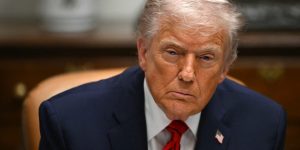 Donald Trump, sitting in the Roosevelt Room, looks forward and frowns.
