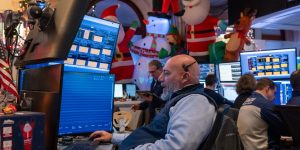 Traders work on the floor of the New York stock Exchange during a shortened trading day before the Christmas holiday on December 24, 2025