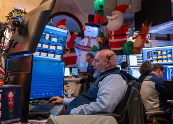Traders work on the floor of the New York stock Exchange during a shortened trading day before the Christmas holiday on December 24, 2025