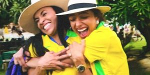 m colorida da jogadora Marta e da atriz Alice Carvalho se abraçando usando blusas da Seleção Brasileira