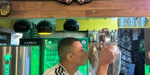 Sósia do jogador Mbappé com a replica da taça _ Divulgação