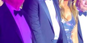 Barron Trump stands between his president after, Donald, and FLOTUS's mother, Melania, at the New Year's party at Mar-a-Lago