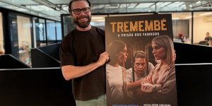m colorida de Ullisses Campbell segurando um cartaz da série Tremembé