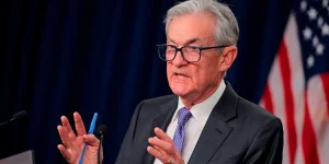 s Jerome Powell seen speaking at a podium. He is motioning with his hands