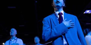 Attendees stand and observe the National Anthem during Turning Point USA's AmericaFest 2025 in Phoenix on December 19, 2025