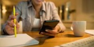 closeup-woman-using-smart-phone-while-learning-evening-home