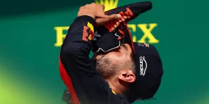 A side-profile shot of Daniel Ricciardo drinking from his shoe on the podium