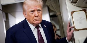 The president stands in the aisle of Air Force One.