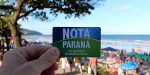 mão segura cartão do Nota Paraná - Metrópoles
