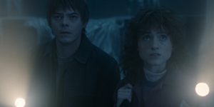 m colorida com filtro azul de Charlie Heaton como Jonathan Byers e Natalia Dyer como Nancy Wheeler em Stranger Things