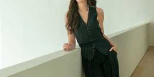 Anne Hathaway sorrindo. Ela veste um conjunto de blusa e calça preto (Reprodução Instagram Anne Hathaway