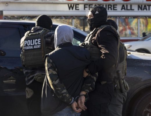 A federal agent arrests a man after stopping and questioning him in the street during an Immigration Enforcement Operation in Minneapolis on January 14, 2026