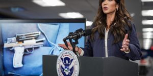 of the pistol recovered by federal agents after a shooting in Minneapolis, Minnesota is shown on a screen behind Secretary of Homeland Security Kristi Noem duri
