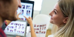 Group of graphic designers smiling while working on computer in office