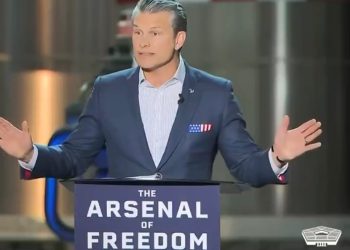 Pete Hegseth speaking at a podium with "The Arsenal of Freedom" written on it.