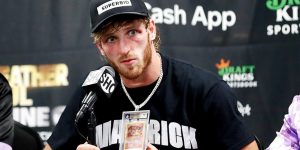 Logan Paul speaks at a press conference while wearing a chain featuring a Charizard Pokémon card