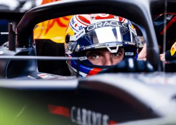Max Verstappen sitting in the cockpit of his Red Bull RB21 with his visor open