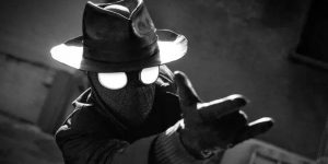 Spider-Noir wearing a hat and pointing his hand up into the air, preparing to shoot a web