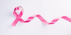 Pink ribbon cancer sign on white