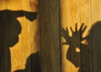 grafia colorida na qual homem aparece ameaçando agredir a mulher que tenta se defender