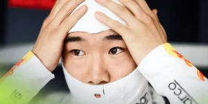Yuki Tsunoda holds his hands to his head as he puts on his balaclava